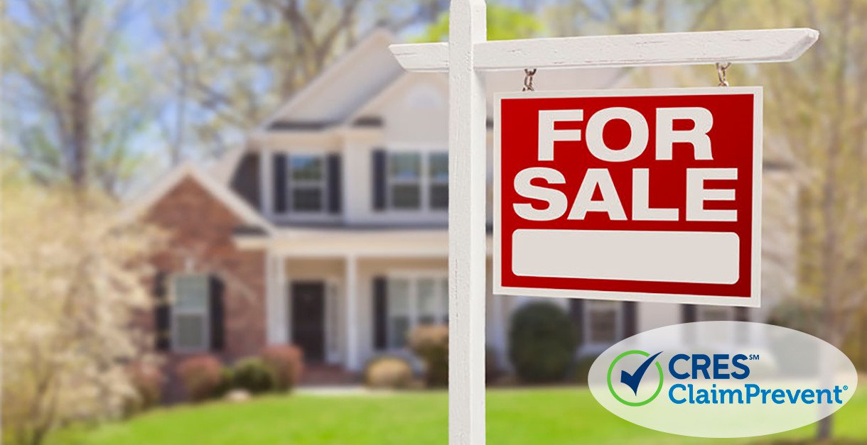 real estate for sale sign in front yard of house