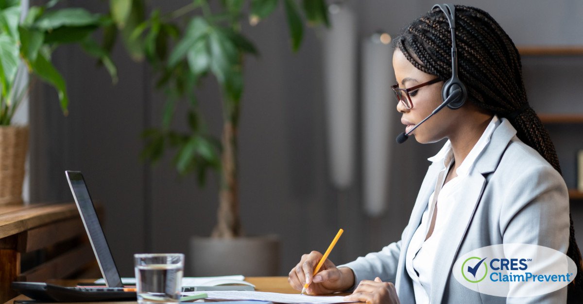 woman with headset writing at desk