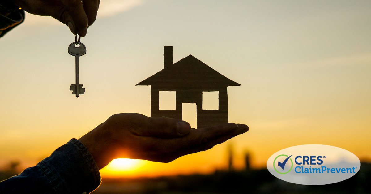 hand holding model of a house and key