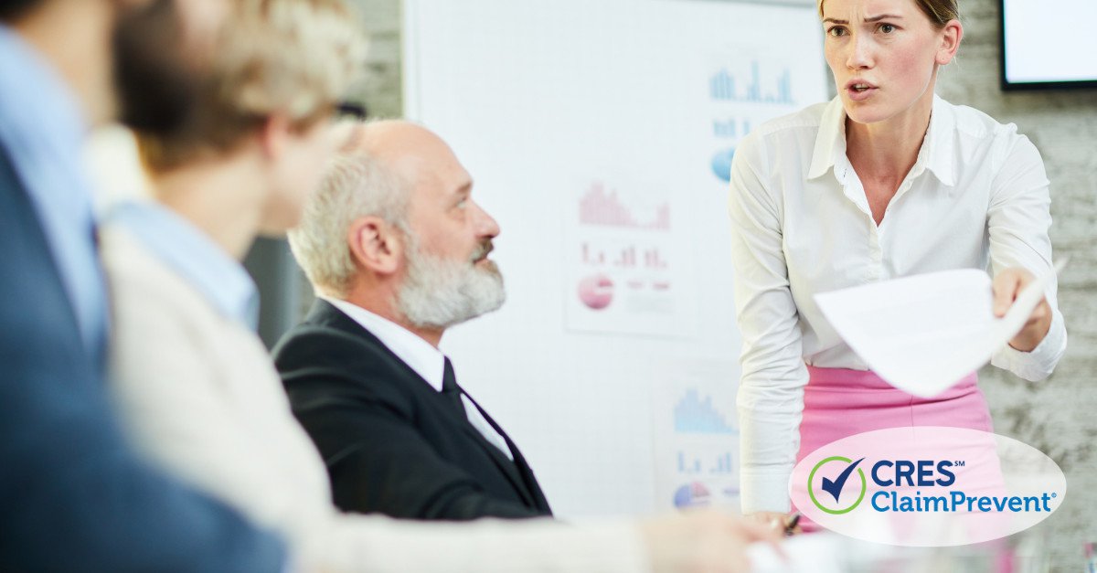 man with beard sitting women with paper standing