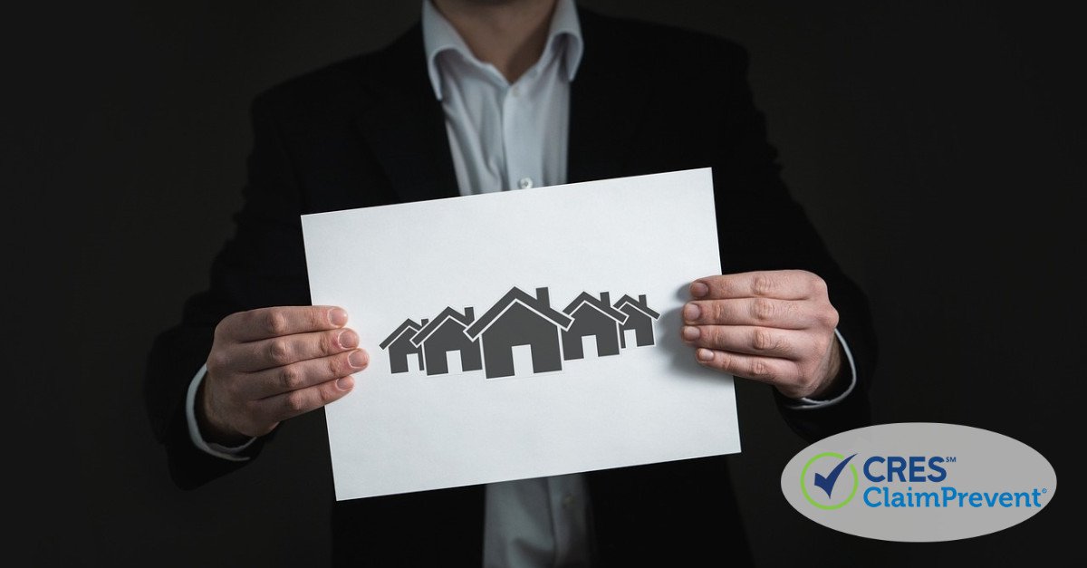 man in suit holding picture of houses