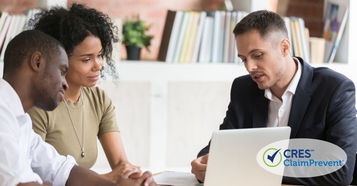 three people at a table in front of lap top