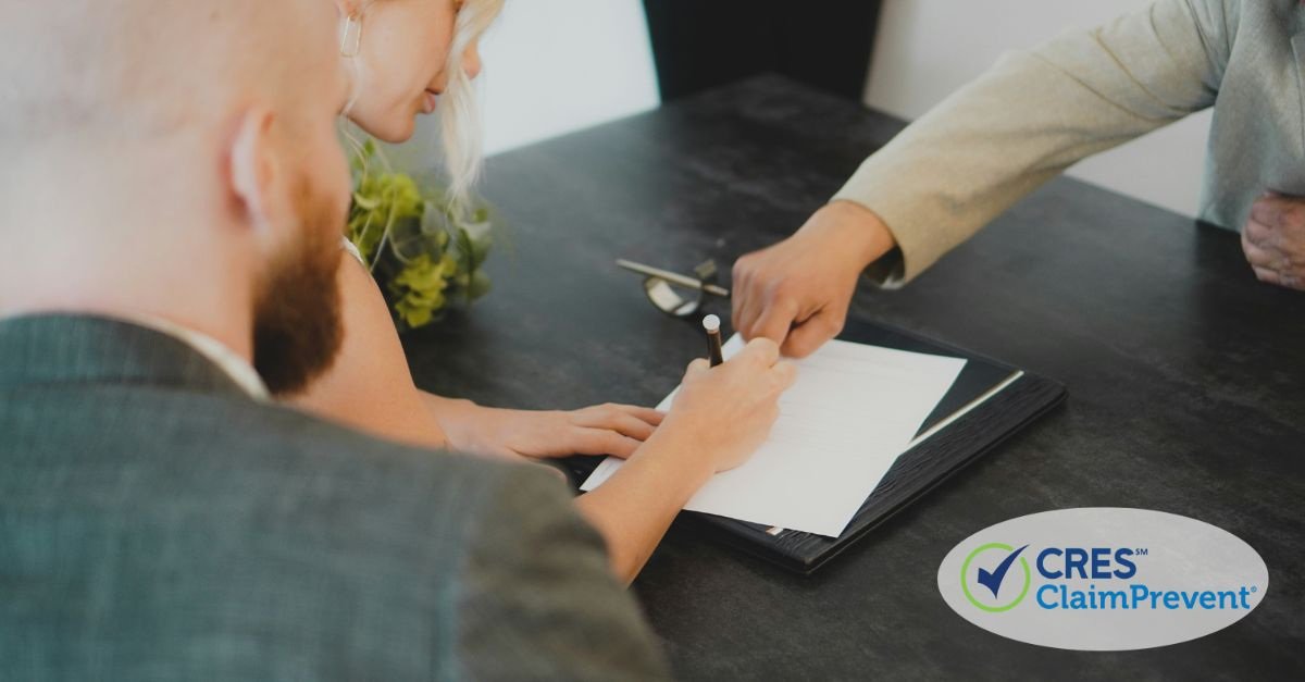 woman signing paper sitting next to man, man pointing to paper